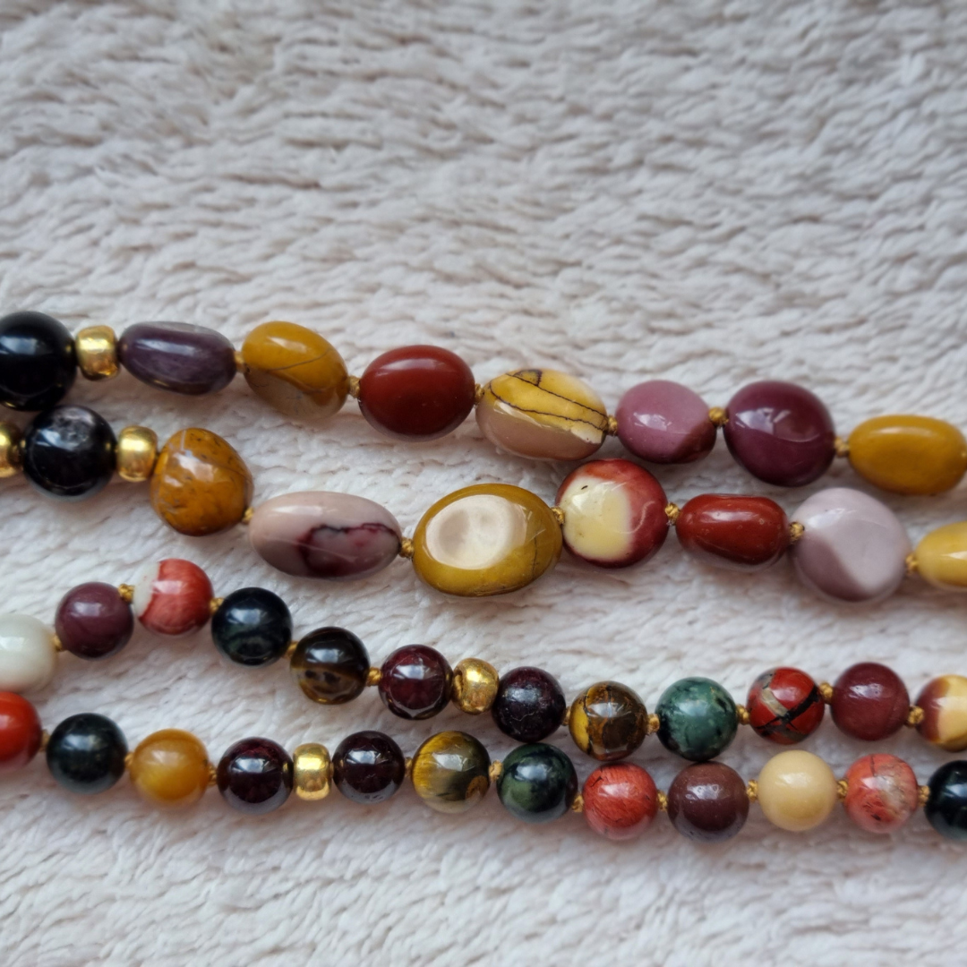 Kralen detailfoto van handgemaakte edelsteen mala met granaat, tijgeroog, kambaba jaspis, rode jaspis, mookaiet en obsidiaan 6mm kralen. Hanger van tijgeroog. 